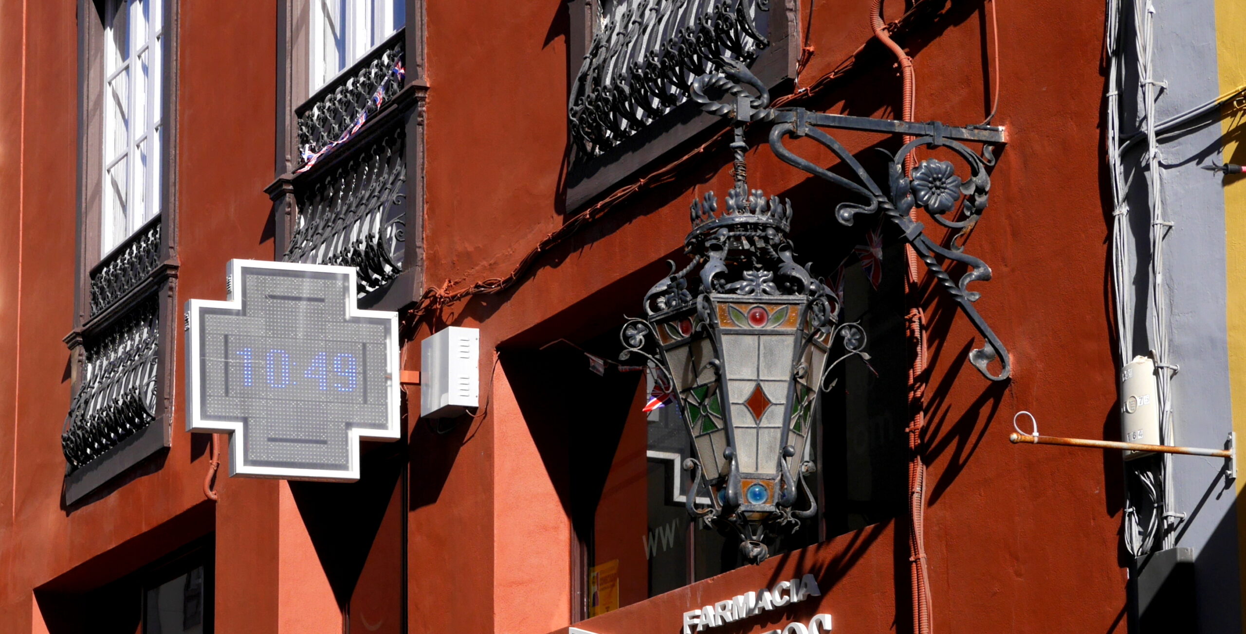 Pharmacy cross sign on a historic facade in the Canary Islands